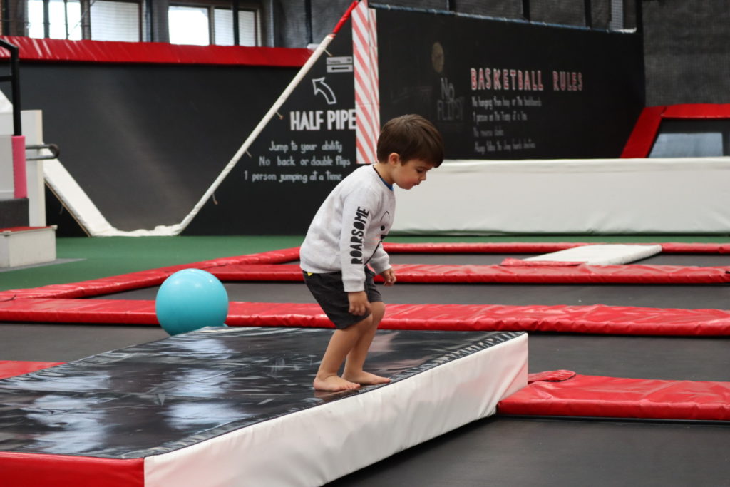 Child balancing on trampoline in toddler zone