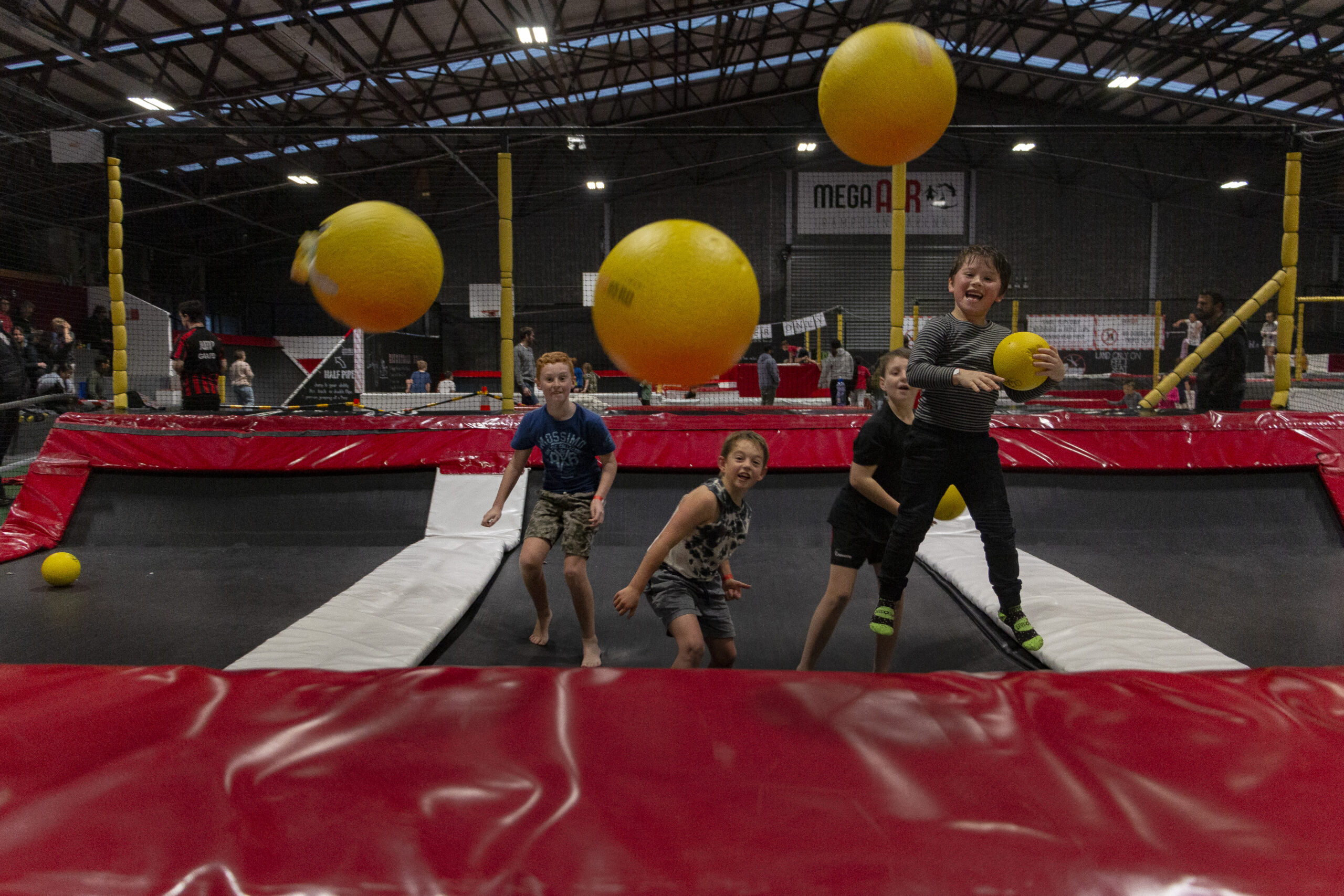 Children playing dodgeball in trampoline arena at Mega Air Holiday Programme